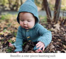 Load image into Gallery viewer, A photo of a baby wearing a knitted onesie. The garment pattern is called Bundle and is from the book, Newfoundland Knits for Little Ones by Katie Noseworthy.
