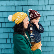 Load image into Gallery viewer, A photo of a woman and a child wearing matching hats. The hat pattern is called Polaris and is from the book, Newfoundland Knits for Little Ones by Katie Noseworthy.