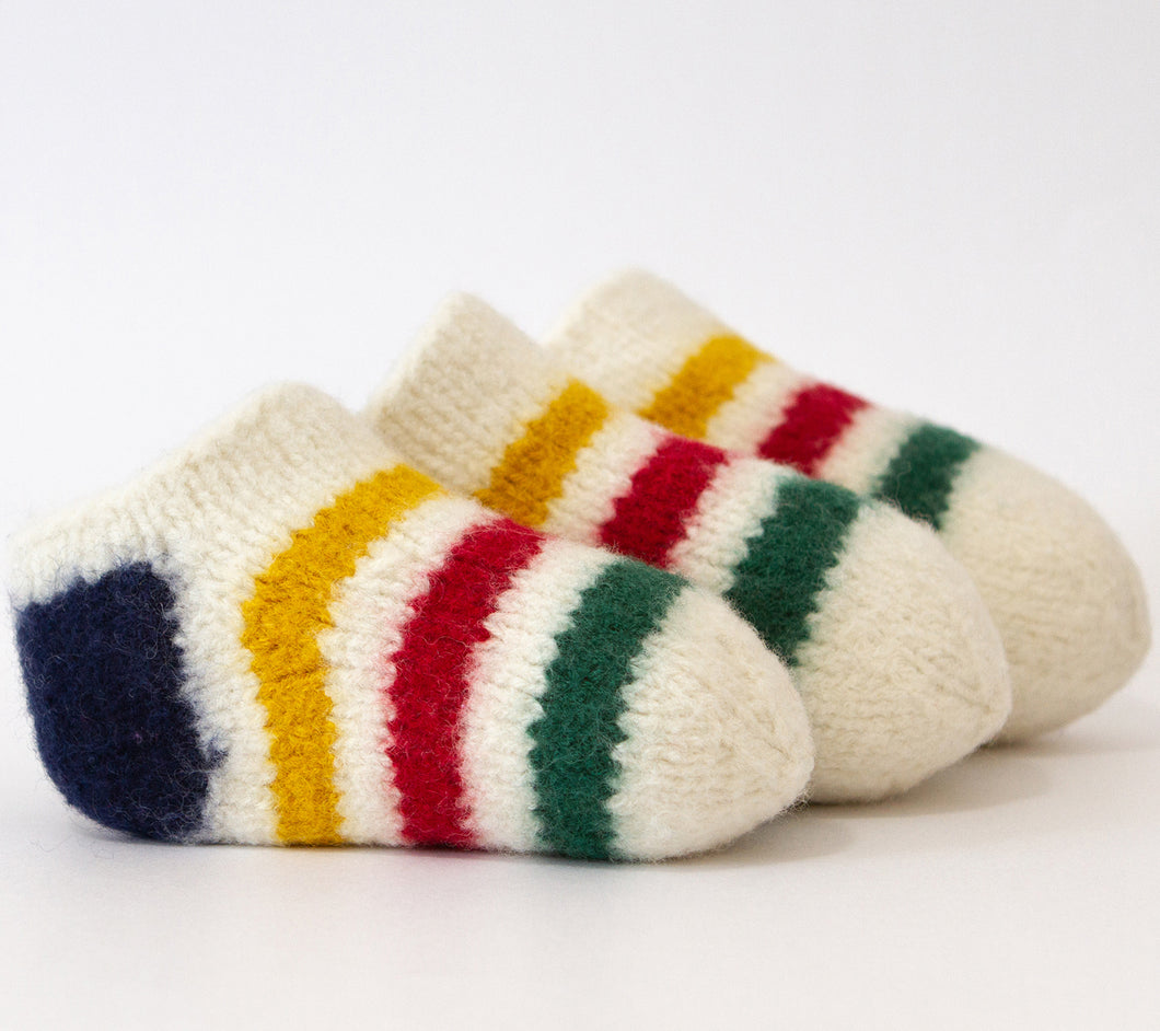 Three RCY Fuzzy Foot Socks in cream with stripes of navy, yellow, red and green
